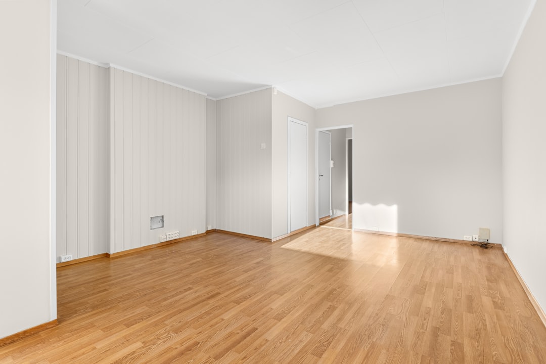 an-empty-room-with-hard-wood-floors-and-white-walls-xrsbr6utxm4